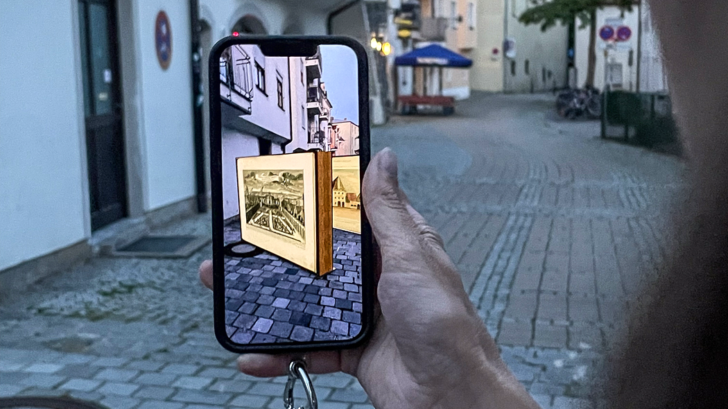 Schwarzes Smartphone zeigt eine Augmented Reality Anwendung in der Stadt an