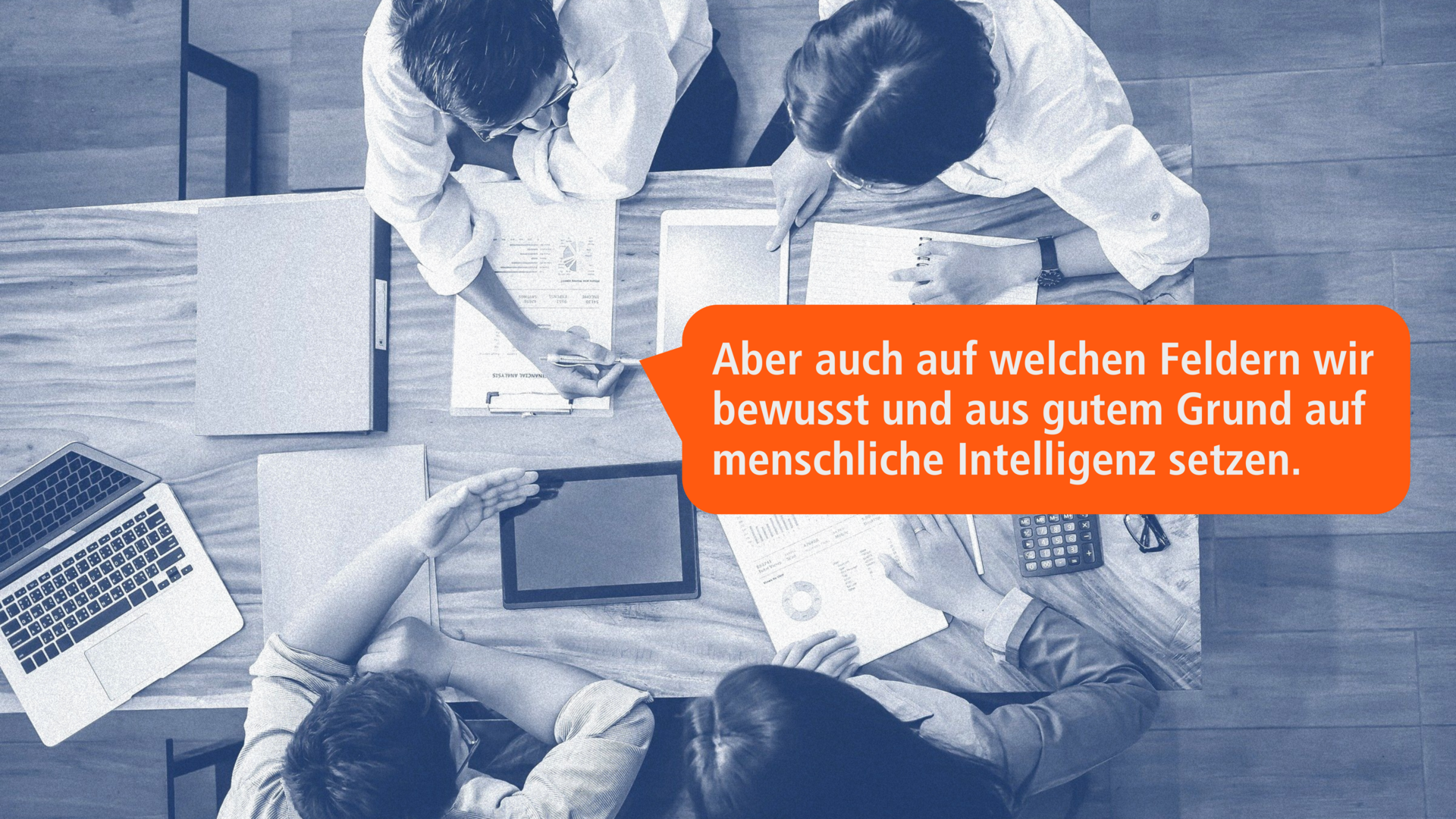 Team-Meeting mit Fokus auf menschliche Intelligenz in der KI-Nutzung – Personen diskutieren über Dokumente, eine orangefarbene Sprechblase hebt hervor, dass menschliche Intelligenz bewusst in den Prozess einfließt.